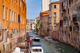 A ﻿boat sails down a beautiful canal in Venice.